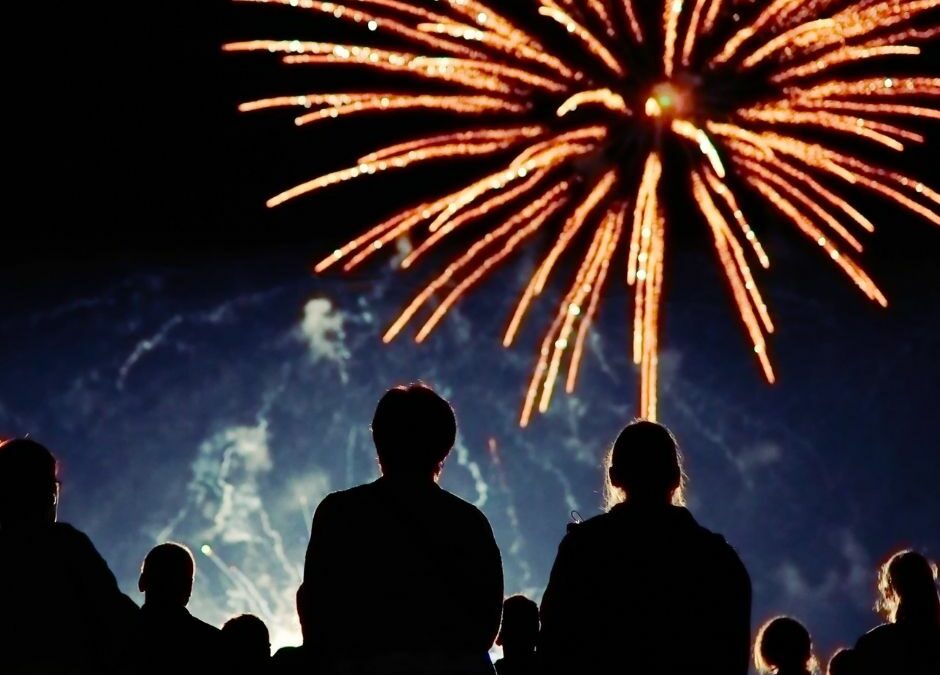 A crowd watches dazzling fireworks light up the night sky, celebrating Mooloolaba NYE with a spectacular beachfront display.