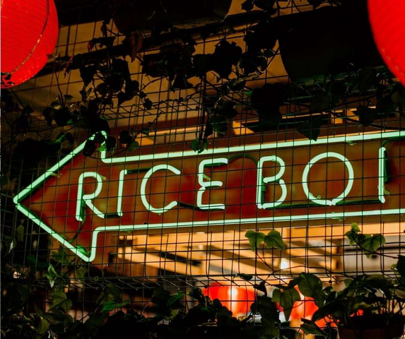 A neon-lit sign at Rice Boi, one of the most popular Mooloolaba restaurants, known for its bold Asian street food and waterfront dining experience.