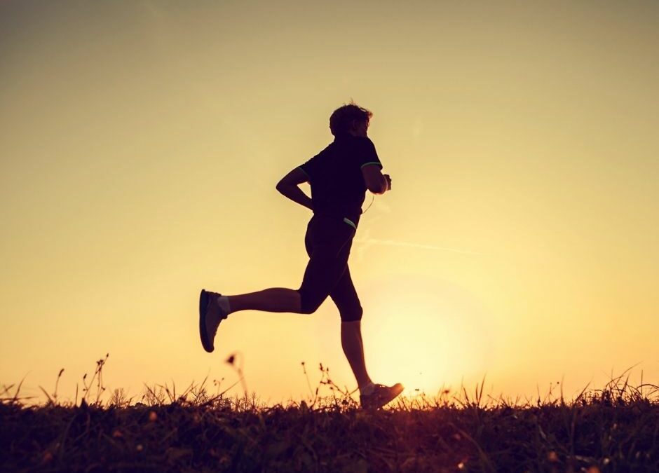 A runner silhouetted against a golden sunset, symbolizing the energy and excitement of sporting events in Mooloolaba.